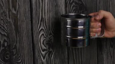 Bir adam, eleme için eleğe un koyar. Tarama sürecini başlatır.