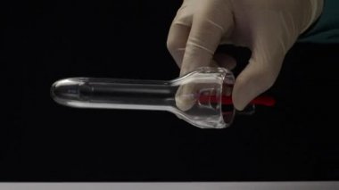 Lastik eldivenli bir doktor tek seferlik jinekolojik ayna gösteriyor. Jinekolojik spekulum Cusco. Yakın çekim.