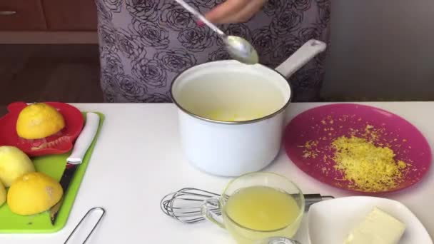 La ragazza mescola gli ingredienti per il kurd al limone in una casseruola. Dopo di che, lo mette su una stufa a gas e si muove durante la cottura. . — Video Stock