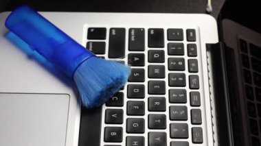 Lastik eldivenli bir adam laptopunu temizliyor. Özel bir peçete dizüstü bilgisayarın klavyesini temizler. Çalışan ekipmanların viral enfeksiyondan korunması.