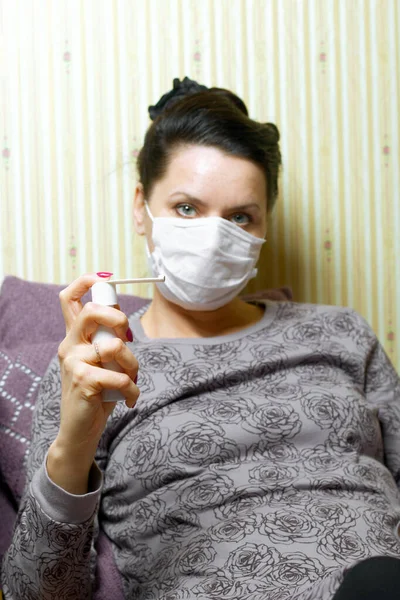 Woman Medical Mask Sits Bed Holds Throat Spray Her Hands — Stock Photo, Image