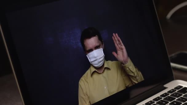 Een videoblogger met een medisch masker neemt een reclamevideo op op de webcam van een laptop op. Hij adverteert abonnees met de middelen om een virale infectie te voorkomen en te behandelen tijdens een epidemie.. — Stockvideo