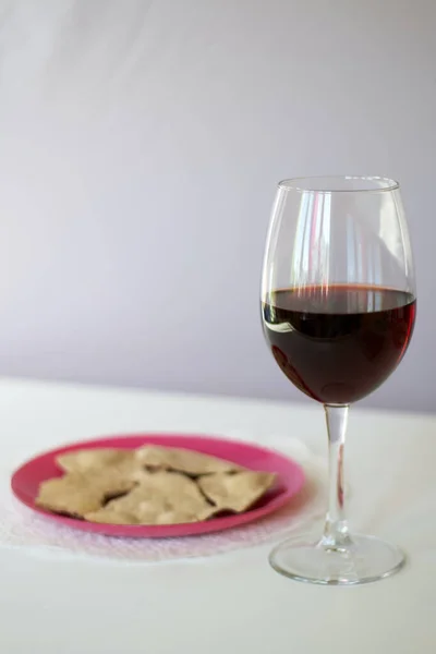 A glass of dry red wine and unleavened bread on a plate. Celebration of the Lord\'s Supper.