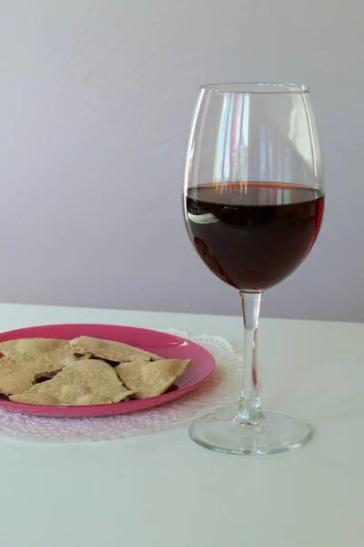 A glass of dry red wine and unleavened bread on a plate. Celebration of the Lord\'s Supper.