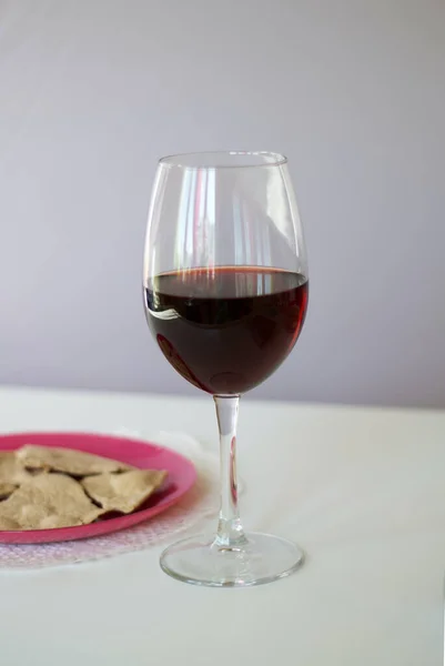 A glass of dry red wine and unleavened bread on a plate. Celebration of the Lord\'s Supper.