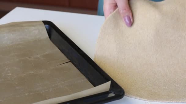 Une femme met un gâteau rond sur une plaque à pâtisserie avec un tapis de silicone. Prépare une tortilla fraîche . — Video