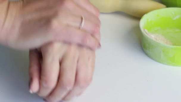 Eine Frau knetet einen Teigklumpen für frischen Kuchen. Kneten mit den Händen auf der Oberfläche des Tisches. Bereitet ungesäuertes Brot zu. Nahaufnahme — Stockvideo
