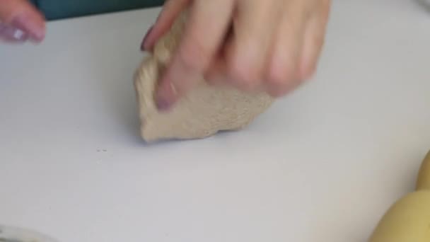 A woman carefully kneads a ball of dough for fresh cakes. Kneading with his hands on the surface of the table. Prepares unleavened bread. Close-up — Stock Video