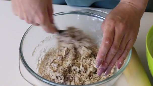 A mulher faz massa para bolos ázimos. Mistura farinha e água em um recipiente de vidro. Prepara pão ázimo — Vídeo de Stock