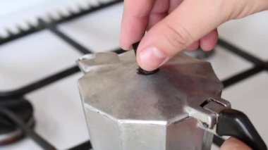 Ocakta bir kahve makinesi var, buhar çıkıyor. Adam kapağı açar, sıcak kahve görünür..