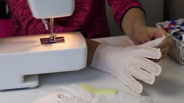 Femme coud des gants en tissu. Essayer un gant fini sur sa main. Travail à domicile . — Video