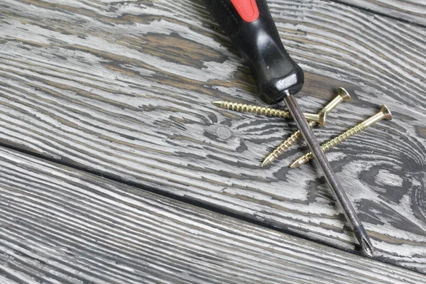 Verschillende Gele Metalen Schroeven Een Schroevendraaier Liggen Grenen Borstelplanken Zwart — Stockfoto