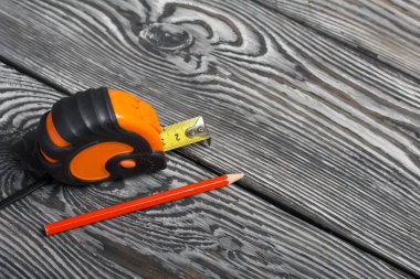 Siyah ve turuncu elementler ve kırmızı kalemle ölçüm yapıyorum. Siyah çam ağaçlarının üzerinde yatıyorlar. İşçi Bayramı 'nın sembolü.