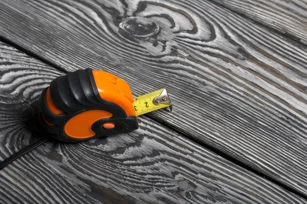 Siyah ve turuncu elementlerle ölçüm yapıyorum. Siyah çam ağacından yapılmış tahtalarda yatıyor. İşçi Bayramı 'nın sembolü.