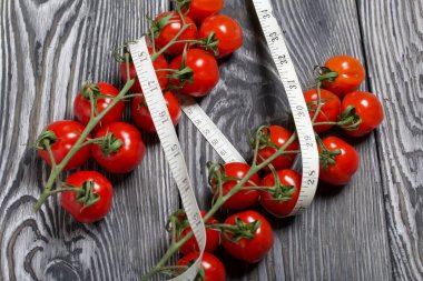 Bir avuç domates. Ölçüm bandının yanında. Çam ağacından yapılmış tahtalarda. Diyet Günü Olmayan Dünya Sembolü.