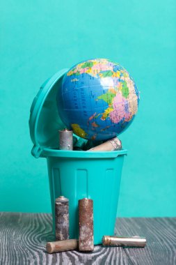 Kapağı atık pillerle dolu bir çöp kutusu. Piller aşınmayla kaplı. Akü küredir. Çevre Günü.