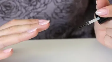 Kız nazikçe tırnaklarına jöle sürüyor. Manikür yapıyor. Kendini izolasyonda özgüven. Yakın çekim..