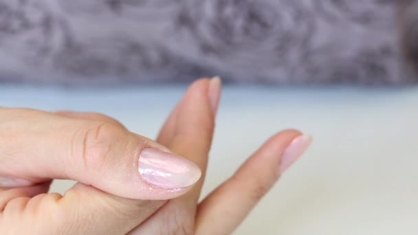 La ragazza fa una manicure in autoisolamento. Applicare delicatamente lo smalto gel sulla miniatura. Primo piano. . — Video Stock