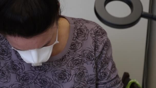 A menina em uma máscara protetora faz a manicura. Aplicar gel polonês nas unhas. Imagem de close-up . — Vídeo de Stock