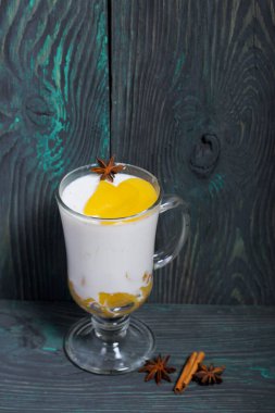 Krema beyazı. Şeftali dilimleri ve anason yıldızıyla süslenmiş..