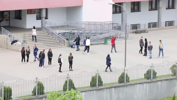 MINSK, BELARUS 15. Mai 2020: Gymnasiasten lernen einen Walzer tanzen. Jungen und Mädchen stehen sich gegenüber. Auf dem Gelände vor der Schule. Vorbereitung auf die Abschlussfeier. — Stockvideo