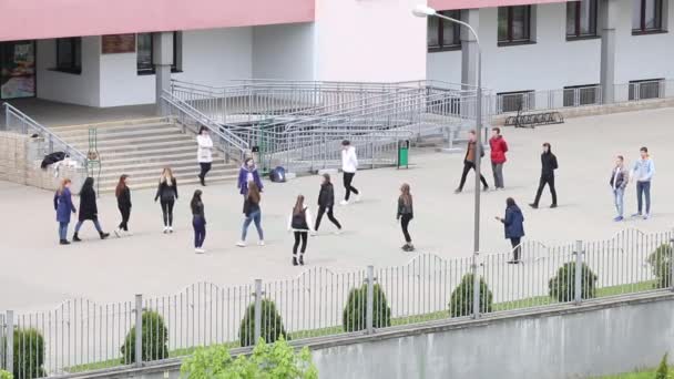 MINSK, BELARUS MAIO 15, 2020: Estudantes do ensino médio aprendem a dançar uma valsa. Rapazes e raparigas a rodopiar para se conhecerem. No local em frente à escola. Preparação para a festa de graduação . — Vídeo de Stock