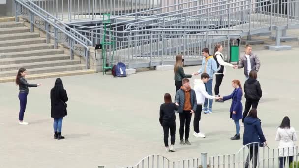 MINSK, BELARUS 15.května 2020: Středoškoláci se učí tančit valčík. Učitel jim pomáhá. Na místě před školou. Příprava na maturitní večírek — Stock video