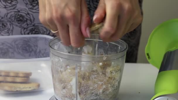 Flickan bryter kakorna och kastar sin mixerskål i skålen. För att göra en efterrätt. — Stockvideo