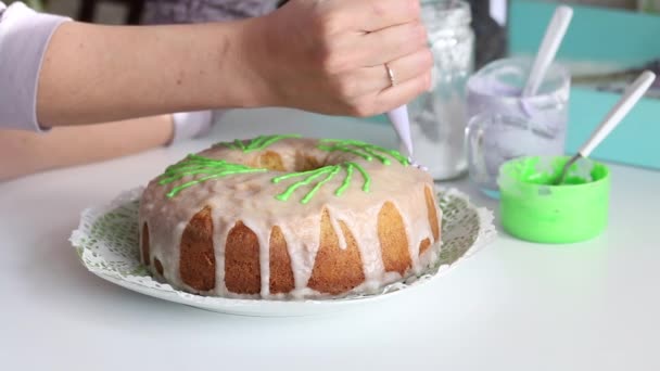 Cupcake di zucchero decorato con elementi verdi. Donna aggiunge oggetti con una borsa da pasticceria . — Video Stock