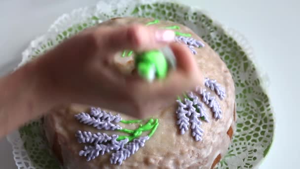 Pastelito de azúcar. Mujer pinta flores de lavanda con esmalte. Usando una bolsa de pastelería. Disparo desde arriba. — Vídeos de Stock