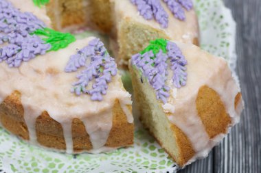 Lavantalı kek. Şeker kaplı. Lavanta rengi çiçeklerle süslenmiş..