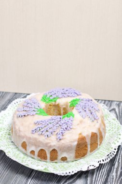 Lavantalı kek. Şeker kaplı. Lavanta rengi çiçeklerle süslenmiş. Küçük bir parça kesilmiş..