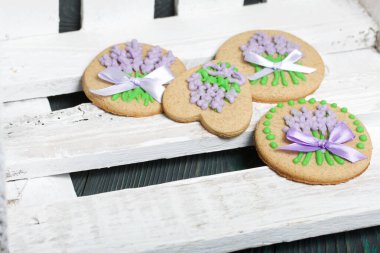 Jöleli zencefilli kurabiye. Fiyonka bağlanmış kurdeleler üzerinde. Beyaz boyalı tahtalara uzan.