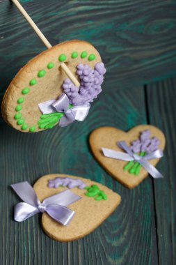 Kurdele ve kremayla süslenmiş zencefilli çörek. Çubuğa asılıydı. Çam ağacından yapılmış tahtalarda.