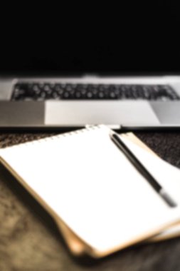 Bir dizüstü bilgisayar ve karanlık bir Danışma, backgr üstünde bir defter bulanık fotoğrafları