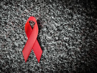 red ribbon on granite, world aids day concept clipart