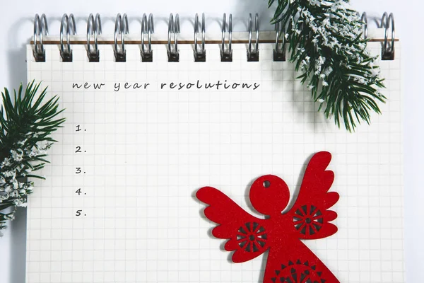 Resoluções do ano novo, bloco de notas em espiral em branco aberto com madeira vermelha — Fotografia de Stock