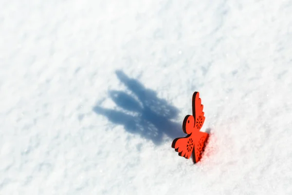 Anjo de brinquedo de madeira vermelho na neve — Fotografia de Stock