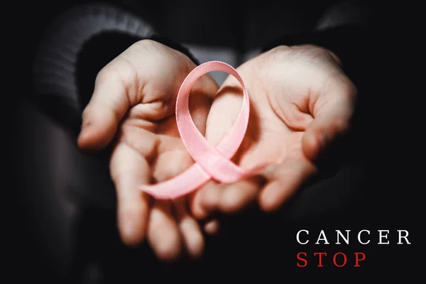 Hälso-och koncept - barn händer hålla cancer awareness ribbon — Stockfoto