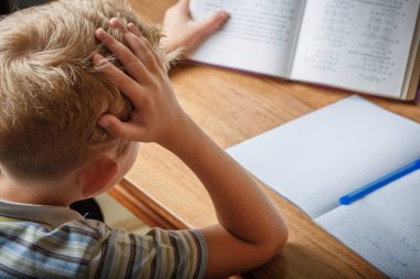Çocuk evde ödevini yapıyor.