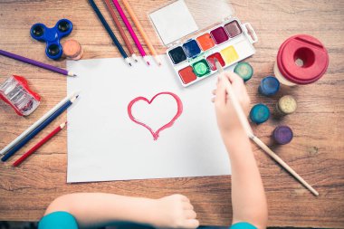 Kağıt üstten görünüm üzerinde renkli kalemler ile şirin çocuk boyar