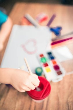 Kağıt üstten görünüm üzerinde renkli kalemler ile şirin çocuk boyar