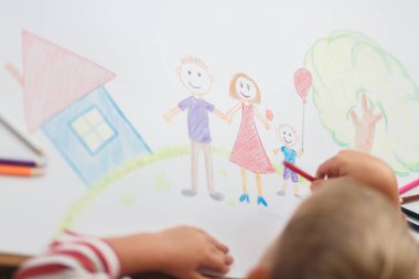 Şirin çocuk ev ve aile kağıt üzerinde çizer