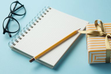 Öğrenci yarıyıl not defteri ile mavi bir arka plan üzerinde hediyeler