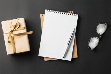 Öğrenci yarıyıl not defteri ile hediye hediye kutuları ile siyah arka plan üzerinde 
