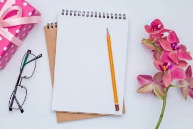 Hediye ve kalem ile beyaz masa üstünde defter