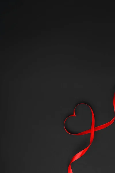 Красная лента в форме сердца на черном фоне, валентный — стоковое фото