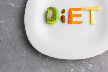 meyve elma, kivi, havuç, fındık, kelime diyet bir plaka üzerinde bir