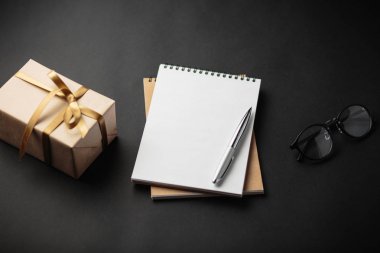 Öğrenci yarıyıl not defteri ile hediye hediye kutuları ile siyah arka plan üzerinde 