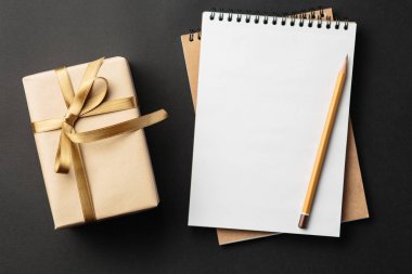 Öğrenci yarıyıl not defteri ile hediye hediye kutuları ile siyah arka plan üzerinde 